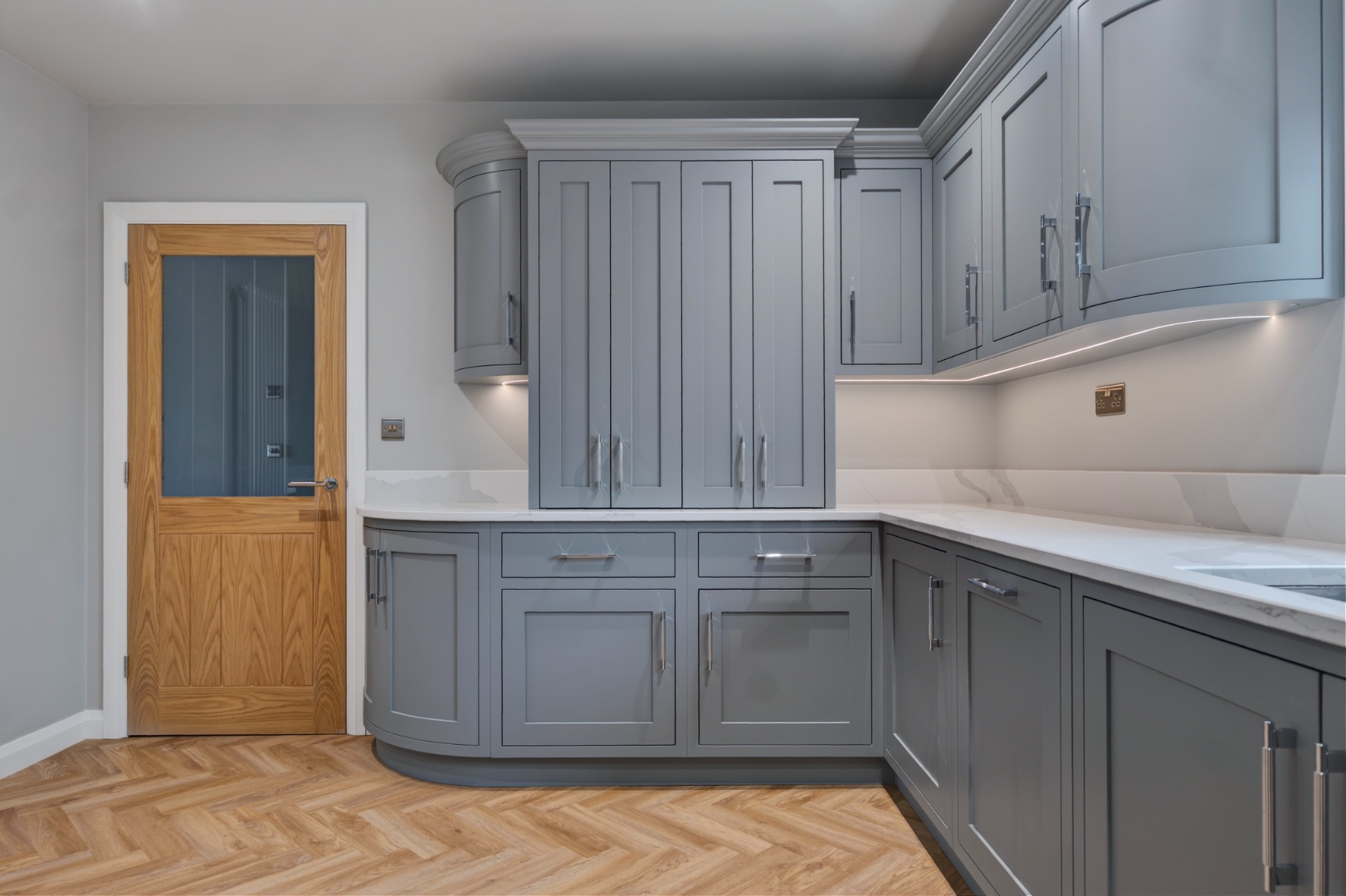 Tall corner cabinet detail with curved cornice — bespoke kitchen cabinetry