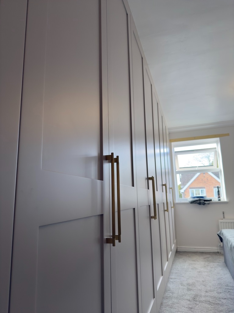 Fitted shaker wardrobes with brushed brass handles — close-up angle
