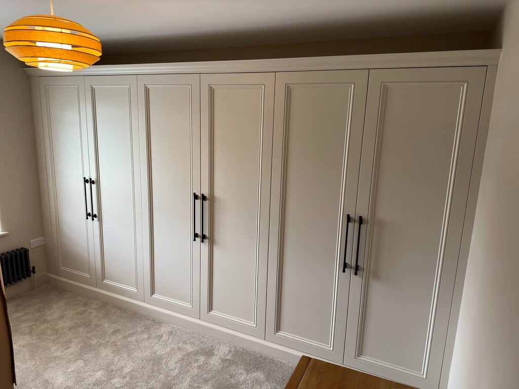 Fitted bedroom wardrobes with in-frame shaker doors and black handles