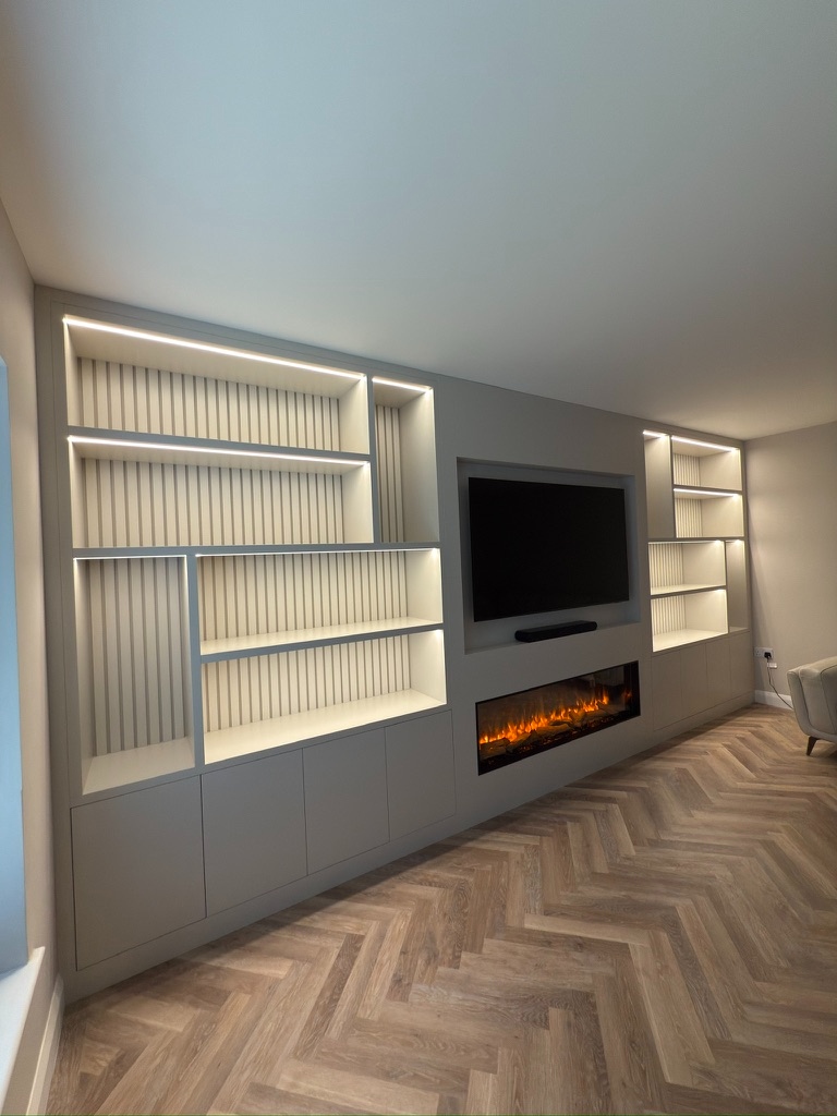 Bespoke media wall from angle showing LED-lit shelving, slatted backing and herringbone flooring