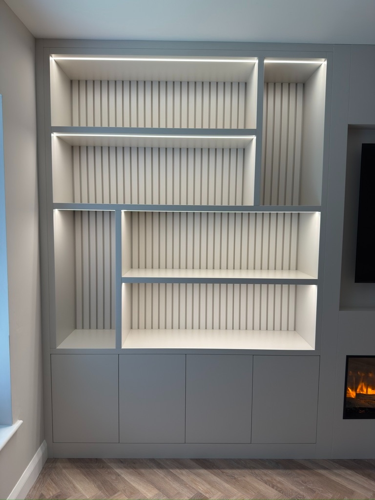 Close-up of media wall shelving with slatted panel backing and integrated LED strip lighting