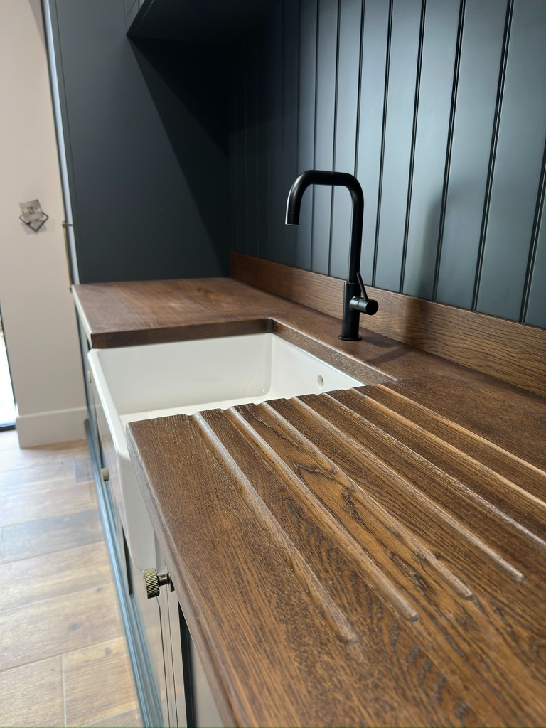 The Stables — stained oak worktop with hand-cut drainer grooves and Belfast sink